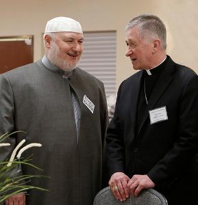 Cardinal Cupich visits with Kifah Mustapha before dinner during the 21st annual Catholic-Muslim iftar dinner at the Mecca Center in Willowbrook on May 25, 2018. The Annual Interfaith Iftar, sponsored by the Council of Islamic Organizations of Greater Chicago, includes breaking the Ramadan fast, observing maghrib prayer and sharing a festive dinner and program. Ramadan 2018 began in the evening of May 15 and ends the evening of June 14. (Karen Callaway/Chicago Catholic)