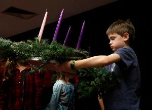 A young boy carries the Advent wreath he made. (Karen Callaway/Chicago Catholic)