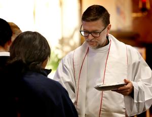 Father Jose Murcia Abellan, pastor of Queen of the Universe Parish, distributes Communion during Mass. (Karen Callaway/ Chicago Catholic)