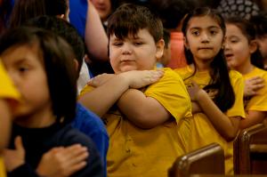 Children fold their arms after receiving a blessing in the Communion line. (Karen Callaway/ Chicago Catholic)