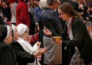 Resurrection junior Casey Brannigan gives Communion to, from left, Resurrection Sisters Gloria Marie Fox, Carolyn Marie Minert and Mary Florence Schultz. (Karen Callaway/Chicago Catholic)