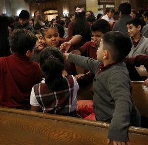 Students from Queen of the Universe share the sign of peace. (Karen Callaway/Chicago Catholic)