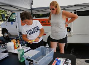 Volunteers Jenny Faulkner and Cathy Bauer, St. Viator parents, look over information given to those receiving the vaccine. (Karen Callaway/Chicago Catholic)