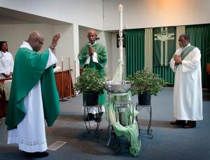 Holy Angels pastor Father Andrew Smith Jr., left, blesses the holy water before Deacon Michael Foggie, center, and Deacon Mervin Johnson, right, take it to fill the fonts around the church. Holy water was not permitted under COVID-19 restrictions. (Karen Callaway/Chicago Catholic)
