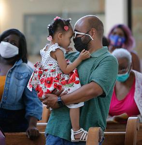 Ian and Michelle Jordon share a father-daughter moment during Mass. (Karen Callaway/Chicago Catholic)