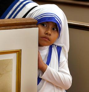 Dressed as a Missionary of Charity, Samara Gomez, 7, peers around a pew during Mass. (Karen Callaway/Chicago Catholic)