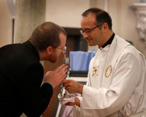 Seminarian Benjamin Paolelli for the Archdiocese of Chicago venerates a relic of St. Mother Teresa of Kolkata following Mass. (Karen Callaway/Chicago Catholic)