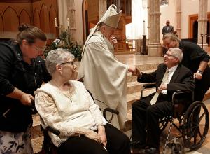 Escorted by their daughters, Aurelia and Ronald Maslana from Mary, Mother of Divine Grace in Winchester greet Cardinal Cupich following Mass. (Karen Callaway/Chicago Catholic)