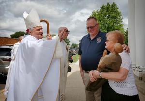 Bishop Manz blesses the statue of St. Hugh held by long-time parishioner Arlene Houda following Mass. The statue hangs in the newly dedicated St. Hugh Faith Formation Center on the Mater Christi campus. (Karen Callaway/Chicago Catholic)