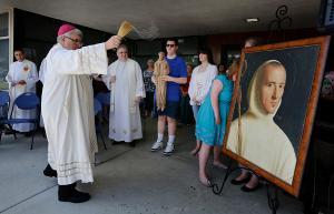 Bishop Manz blesses a portrait and statue of St. Hugh during the dedication of the new St. Hugh Faith Formation Center on the Mater Christi worship site. (Karen Callaway/Chicago Catholic)