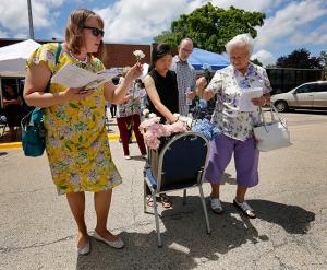 Parishioners take a flower as an offering to be placed near the Mother of Mothers Shrine at the Mater Christi worship site. (Karen Callaway/Chicago Catholic)