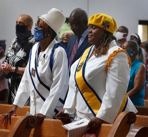 On right, Tasha McShan, supreme steward of the Ladies of Grace, fourth degree, of the Ladies Auxiliary of the Knights of Peter Claver, prays during Mass. (Karen Callaway/Chicago Catholic)
