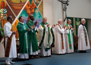 Priests and deacons clap their hands to the sacred music at the start of Mass. (Karen Callaway/Chicago Catholic)