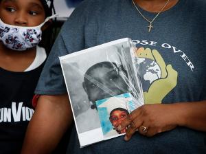 A woman holds a photo of a loved one lost to gun violence. (Karen Callaway/Chicago Catholic)