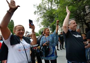 People raise their hands in response to speakers. (Karen Callaway/Chicago Catholic)