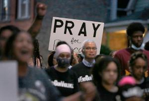 People hold signs while walking through Auburn-Gresham. (Karen Callaway/Chicago Catholic)
