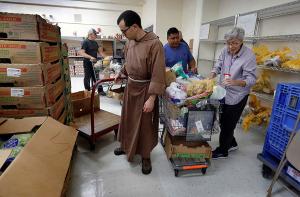 Brother Matt of the Franciscans of the Eucharist of Chicago helps inside the pantry. (Karen Callaway/Chicago Catholic)