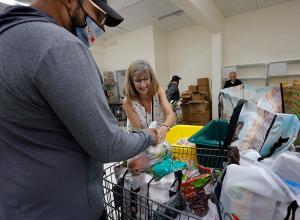 Kathy McLennan, a parishioner at Mary Seat of Wisdom, helps a guest choose fruits and vegetables. (Karen Callaway/Chicago Catholic)