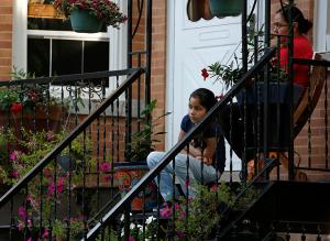 Neighbors attend Mass from their porches. In the days before the Mass, parishioners knocked on doors in the neighborhood to invite people to Mass. (Karen Callaway/Chicago Catholic)