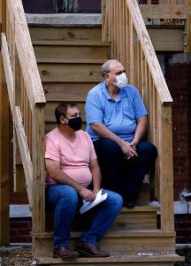 Neighbors attend Mass from their porch steps. (Karen Callaway/Chicago Catholic)