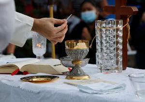 Father Marulanda holds the host. (Karen Callaway/Chicago Catholic)