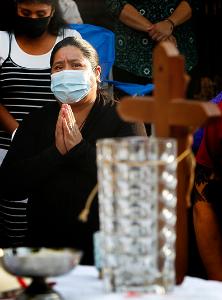 A woman kneels on the street during the eucharistic prayer. (Karen Callaway/Chicago Catholic)