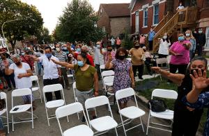 The congregation extends their hands during a blessing of all the children and youth who attended the Mass. The blessing is a tradition during street Masses in Latino parishes. (Karen Callaway/Chicago Catholic)