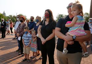 Members of the Janachowski family watch the flag being raised to half-staff during a service before Mass. (Karen Callaway/Chicago Catholic)