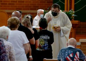 Father Artur Sowa gives Communion to Anna Walsh. (Karen Callaway/Chicago Catholic)