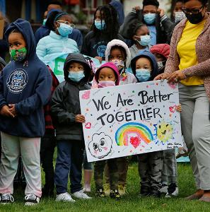 Students hold a sign saying “We Are Better Together” while listening to their principal before the march begins. (Karen Callaway/Chicago Catholic)