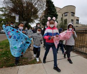 Students carry signs during the walk. Academy alumni who attend Leo High School also joined the march. (Karen Callaway/Chicago Catholic)