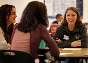 Nazareth Academy Junior Evelyn Siffermann smiles while creating an idea board with her group. (Karen Callaway/Chicago Catholic)