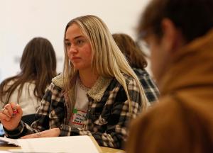 Catherine “Coco” Thompson, a senior at Loyola Academy, takes notes during a group discussion. (Karen Callaway/Chicago Catholic)