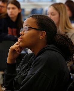 Martine Duplessy from Loyola Academy listens to student presentations. (Karen Callaway/Chicago Catholic)