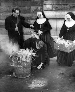 THEN: on Feb. 13, 1953, Father George Halpin lights palms from the previous year to be used for Ash Wednesday at the cathedral. With him are Father Robert Herne and Holy Family Sisters M. Felix and M. Anthony. (Chicago Catholic file photo)
