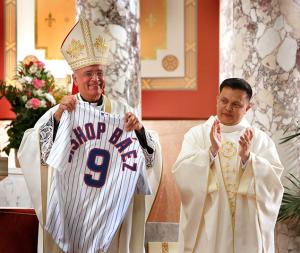 The bishop holds up a personalized Chicago Cubs' jersey that he received from the congregation. The church is located close to Wrigley Field. (Karen Callaway/Chicago Catholic)