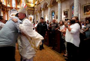 Bishop Báez embraces a participant as he makes his way up the aisle at the end of Mass. (Karen Callaway/Chicago Catholic)