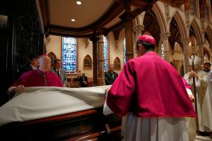 Chicago Auxiliary Bishops Jeffrey Grob and Mark Bartosic place the pall over the casket of Bishop Kevin Birmingham during the Rite of Reception at Holy Name Cathedral on Oct. 6, 2023. The bishop was 51 and died a few days shy of his 52nd birthday. (Karen Callaway/Chicago Catholic)