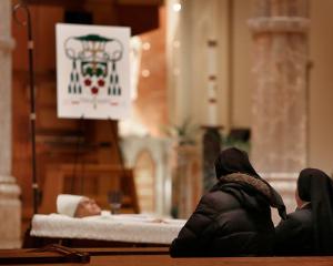 Oblate Sisters of Jesus the Priest pray before the casket of Bishop Birmingham during visitation at Holy Name Cathedral in Chicago on Oct. 6, 2023. The sisters, who ministered at Niles College and Mundelein Seminary, arranged for his second Mass as a priest to be celebrated from the main altar at the Basilica of Our Lady of Guadalupe in Mexico City. He made the trip to Mexico after his ordination to give thanks to Our Lady of Guadalupe, to whom he developed a devotion while he was in seminary, especially when he spent time in Morelia, Mexico, learning Spanish. (Karen Callaway/Chicago Catholic)