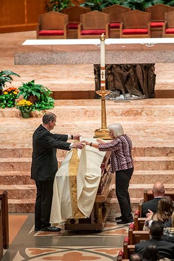 Bishop Birmingham’s mother, Jeanette, and his brother Mark, a funeral director who arranged his brother's services, lay the pall over his casket before the start of his funeral Mass on Oct. 7, 2023 at Holy Name Cathedral. (Deacon Randy Belice/Chicago Catholic)