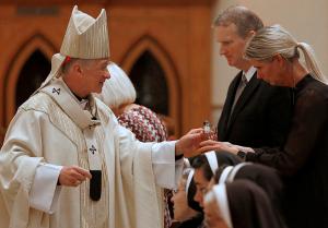 Cardinal Cupich accepts the gifts from Bishop Birmingham's siblings. (Karen Callaway/Chicago Catholic)