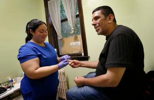 Doctor Patricia Ramirez, Free Clinic Coordinator, checks a patients sugar levels during a visit to the clinic.  Staff see patients as part of the Port Ministries Health Clinic on Aug. 6, 2024. The Port Ministries Free Health Clinic, located at 5013 S. Hermitage Ave.,  provides primary and urgent care to the under and uninsured residents of Chicago’s south side neighborhoods. The clinic is staffed by volunteer medical staff and practitioners. Services include chronic disease management, mental health, urgent care, minor laboratory testing, pharmaceutical administration, physicals and referrals. The Health Clinic provides free physical and mental healthcare to over 1,400 patients per year. (Karen Callaway/Chicago Catholic)
