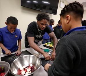 Chef Sebastian White from The Evolved Network shows students a technique. (Karen Callaway/Chicago Catholic)