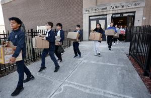 Students carry boxes packed with food to vans. (Karen Callaway/Chicago Catholic)