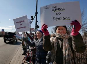 Sisters of Mercy Jacquie Dewar and Anita Taler and Society of Helpers of the Holy Souls Sister Cecile Leung hold up signs to show people passing by in cars. (Karen Callaway/Chicago Catholic)