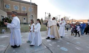 Father Carrillo carries the monstrance while Deacon Uruchima leads a procession from the church to the front of the school. Deacon Shallcross carries the Gospel. (Karen Callaway/Chicago Catholic)