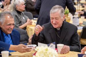 Cardinal Cupich is offered a date as a first food as Muslims prepare to break their Ramadan fast. (Deacon Randy Belice/Chicago Catholic)