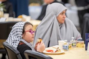 A Muslim girl enjoys a paczki following her meal. (Deacon Randy Belice/Chicago Catholic)