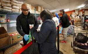 Father John Adio assists a client with vegetable oil and syrup. (Karen Callaway/Chicago Catholic)