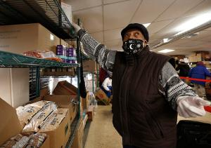 Volunteer Merline Jenkens reaches for a box of lightbulbs to assist a client. (Karen Callaway/Chicago Catholic)